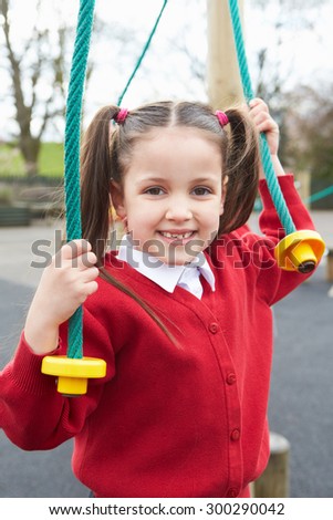 Girl Playing On Climbing Frame In School Playground