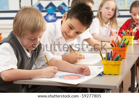 Group Of Primary Schoolchildren In Classroom Working At Desks