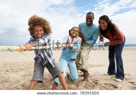 Family playing tug of war on beach