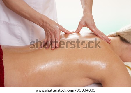 Woman with tattoo having back massage