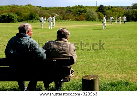 A couple of elderly citizens watching a village cricket match