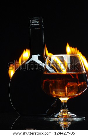 cognac  bottle in fire on black