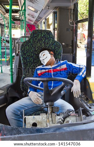 ISTANBUL - JUNE 08: Man sleeping with Guy Fawkes mask in damaged bus during protests on June 08, 2013 in Istanbul, Turkey. Guy Fawkes masks widely used and became a symbol of protests in Turkey.