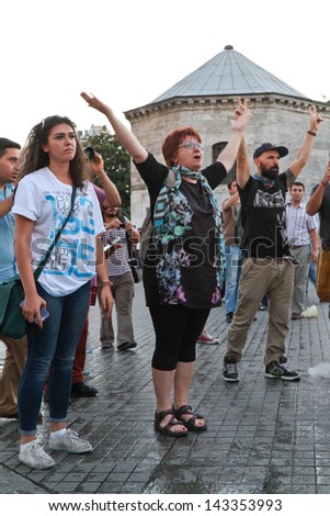 ISTANBUL - JUNE 22: People try to stop police intervention in Istiklal Street on June 22, 2013 in Istanbul, Turkey. People came Taksim Square with carnations to commemoration for dead during protests