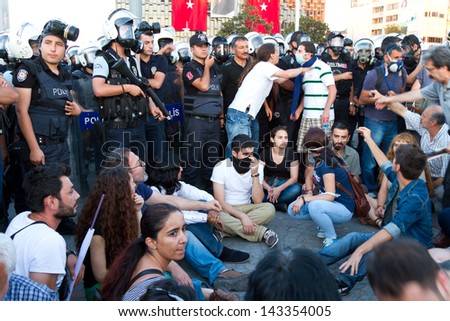ISTANBUL - JUNE 22: People make stay-down strike in front of police on June 22, 2013 in Istanbul, Turkey. People came Taksim Square with red carnations to commemoration for dead during protests