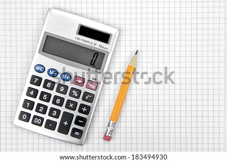 Calculator and lead pencil on squared paper.