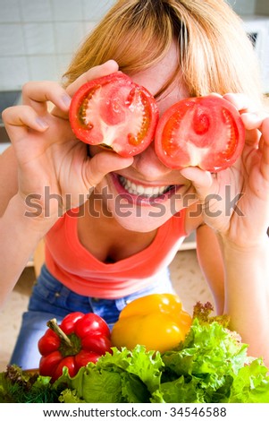 The laughing loudly girl holds a tomato