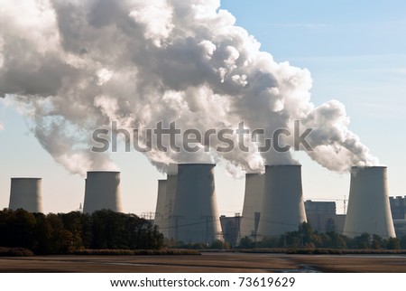 Cooling towers of a power plant with steam clouds and sky