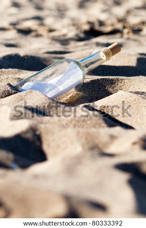 a message in a bottle lies in the sand on the beach