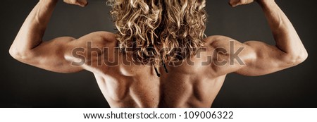 Very Fit and Toned Female BodyBuilder showing her Back Muscles