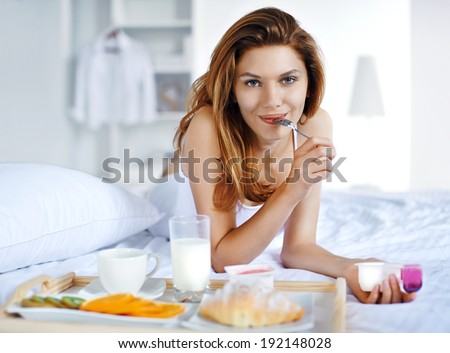 How to eat healthy? / portrait of young beautiful girl with spoon in her mouth