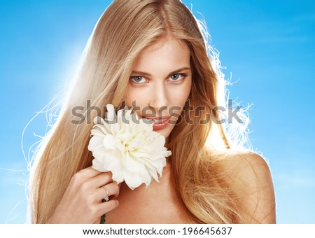 Woman with peony flower / portrait of girl with white peony flower in her hand on blue background