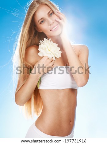 Summer vacation style / portrait of happy smiling girl with white flower in her hand on blue background