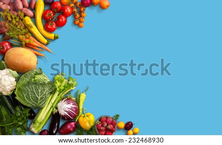 Super food background / studio photo of different fruits and vegetables on blue backdrop