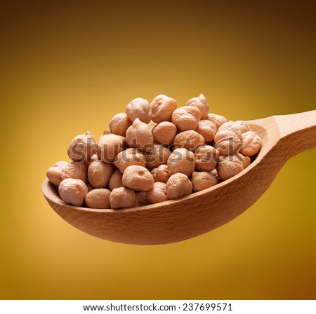Chickpea in a wooden spoon / beans on wooden spoon isolated on golden background