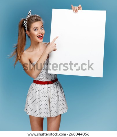 Pinup woman shows forefinger hand on the blank banner / photo set of young American pin-up model on blue background with space for text