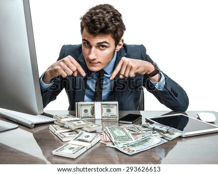 Manager showing his earnings, profit, income, gain, benefit, margin / modern businessman at his desk with computer and a lot of money
