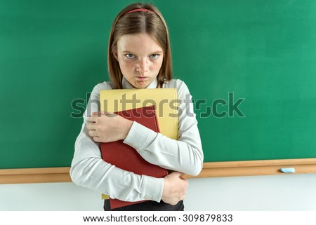 Upset little girl holding school books / photo of teen school girl, creative concept with Back to school theme