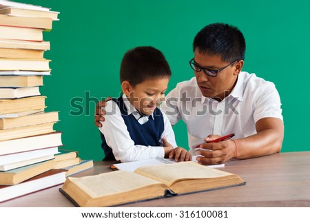 Teacher helps the student / learning in the classroom / photo of teen school Chinese boy / school teacher and student school theme