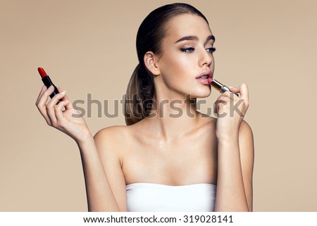 Tempting young woman with  lipstick / photography of mixed race Latina Brazilian brunette smiling girl on beige background