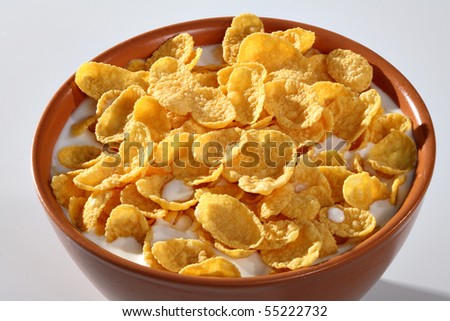 Bowl with corn flakes and milk on the white background