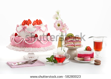 Luxury composition with a pie, tea, fruit cakes and flowers. Sweets from a confectioner\'s shop on a birthday party.