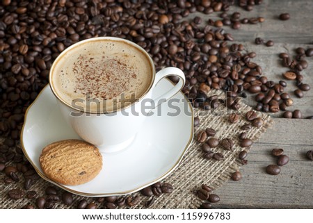 Cappuccino and coffee beans vintage still life on wooden boards