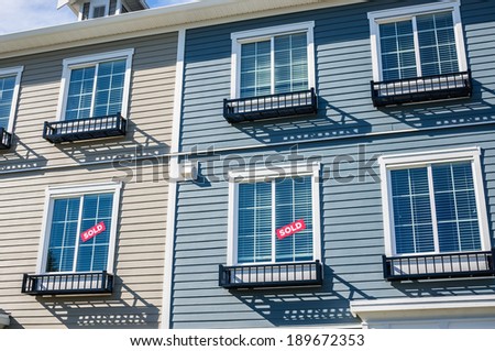Architectural details of modern apartment building. Sign SOLD in the windows.