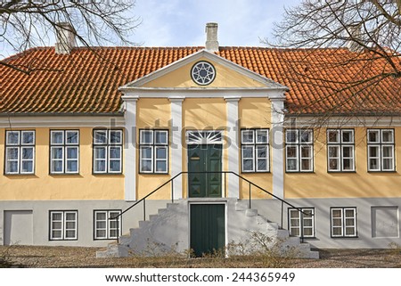Old yellow scandinavian house with a red roof