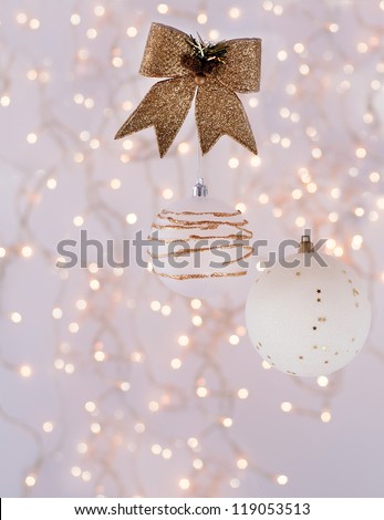 Christmas decorations in the form of white with gold balls on the background of an abstract background - bokeh.