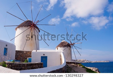 Two windmills of Mykonos. White buildings, blue sky and the sea - the national colors of Greece