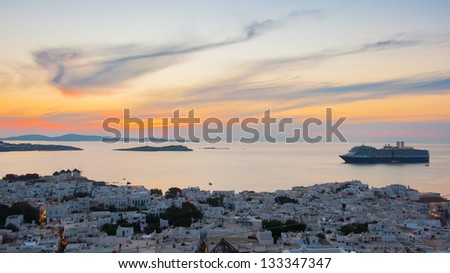 Top view of the town of Mykonos with Windmills at sunset and cruise ship.