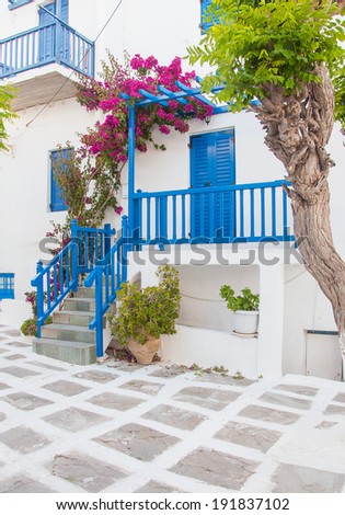 Bougainvillea flowers around the house with a balcony and flowers. Mykonos.