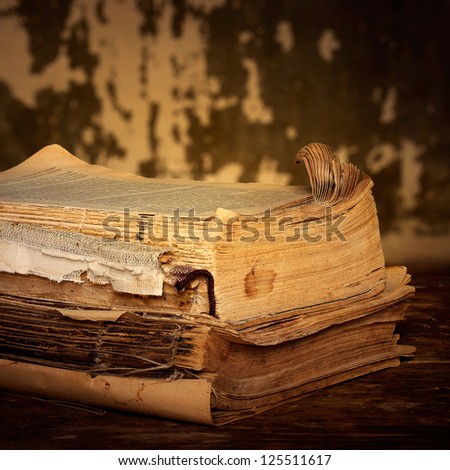 Old books of the Old binder are stacked on a wooden surface