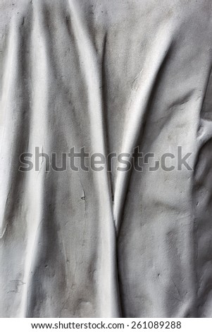 Bas-relief in the form of folds of drapery fabric as a background element design cement and stone walls.