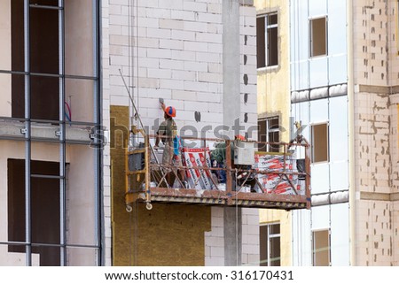 ODESSA - SEPTEMBER 8: facade thermal insulation works with stopping and fillers during the construction of high-rise apartment building September 8, 2015 in Odessa, Ukraine.