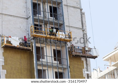 ODESSA - SEPTEMBER 8: facade thermal insulation works with stopping and fillers during the construction of high-rise apartment building September 8, 2015 in Odessa, Ukraine.
