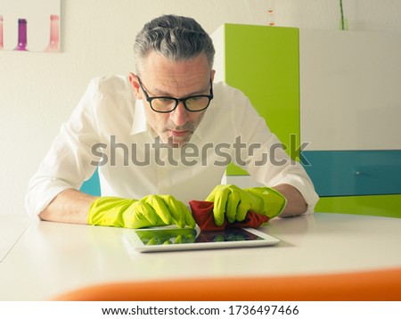 Similar – Image, Stock Photo Middle-aged man thoroughly cleans a tablet computer