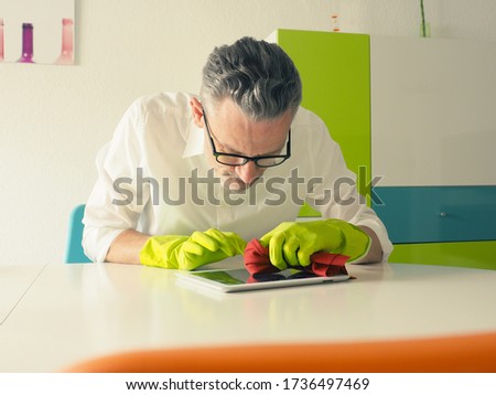 Similar – Image, Stock Photo Middle-aged man thoroughly cleans a tablet computer