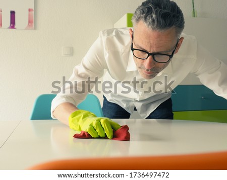 Similar – Image, Stock Photo Middle-aged man thoroughly cleans a tablet computer