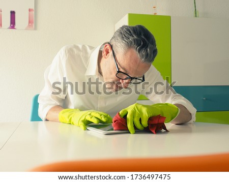 Similar – Image, Stock Photo Middle-aged man thoroughly cleans a tablet computer