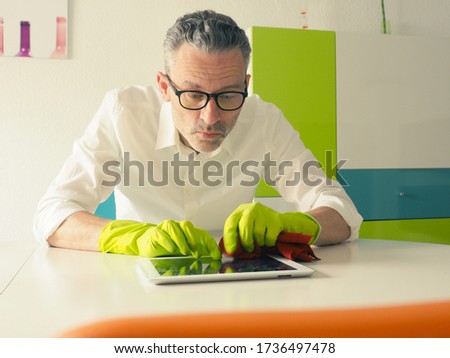 Similar – Image, Stock Photo Middle-aged man thoroughly cleans a tablet computer