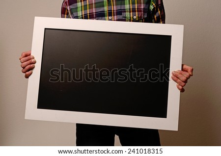A man holding a blank blackboard with space for text or image