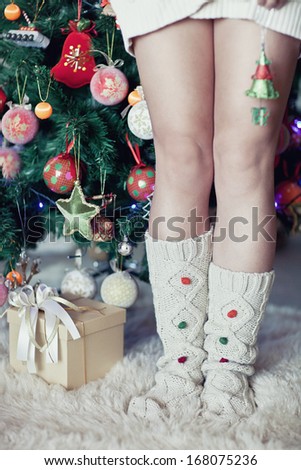woman\'s leg under new year tree with christmas present