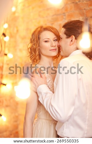 Young man and woman together over brick red wall and lights