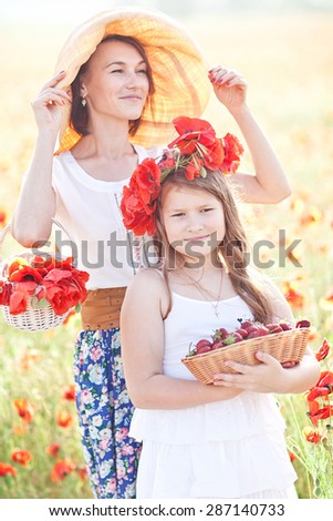 Mother and daughter walking in a poppy field. Summer mood