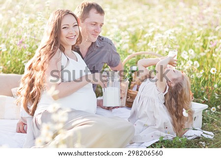 happy little girl drinking milk in the camomile field. picnic