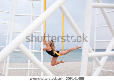 Young woman doing yoga exercise. Yoga with hammock. Anti gravity yoga. Yoga by the sea.
