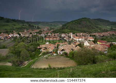 Transylvanian Valea Viilor village with fortified church and lightning in the sky