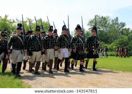 TORONTO - JUNE 15: Royal soldiers\' marsh at reenactment of the conflict of Revolutionary War between refugees and Loyalists at  Black Creek -  in June 15 2013 in Black Creek Village, Toronto, Canada